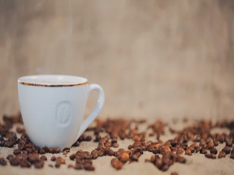 Coffee cup on a  table with coffee beans. Slow motion Stock Footage 73670459