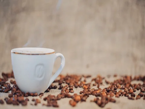 Coffee cup on a  table with coffee beans. Slow motion Stock Footage 73671793
