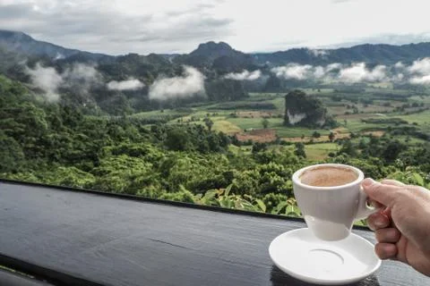 Coffee cup on table with Mountain views in the morning as a background Stock Photos