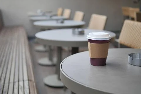 Coffee cup on a table in an outdoor cafe setting Stock Photos