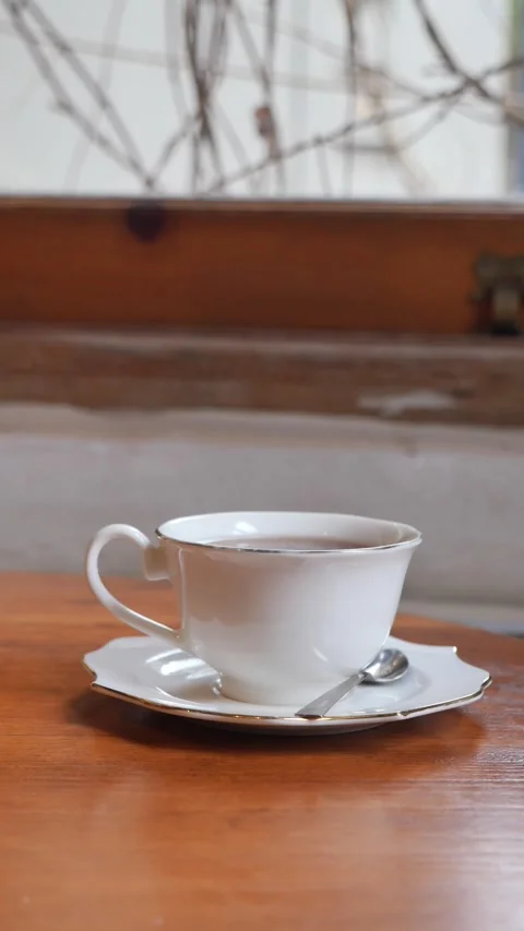 Coffee cup on table with spoon in a cozy setting Stock Footage 335190747