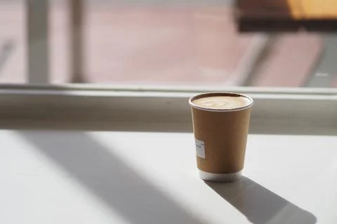 Coffee cup on a table with sunlight coming through window Stock Photos