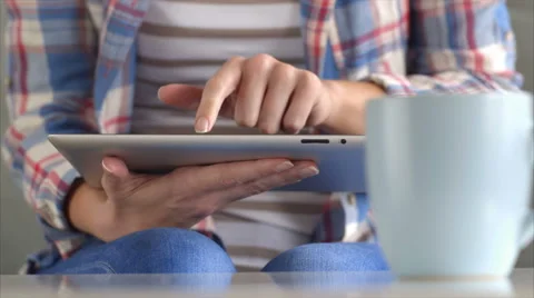 Coffee cup on table with woman using tablet computer Video stock 54783633