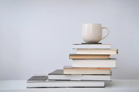 Coffee cup tea mug on stack of books Stock Photos