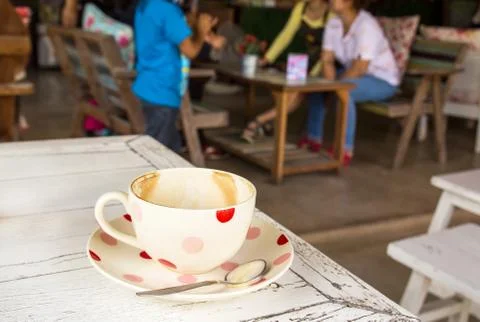 Coffee cup on white wooden table in coffee shop Stock Photos
