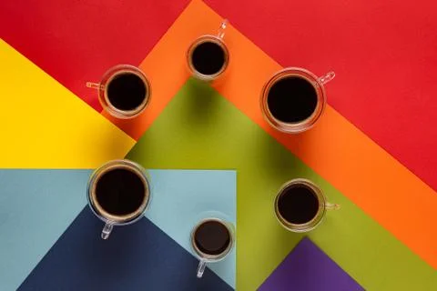 Coffee cups in circle on rainbow background Stock Photos