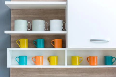 Coffee cups on the shelf in kitchen room . Stock Photos