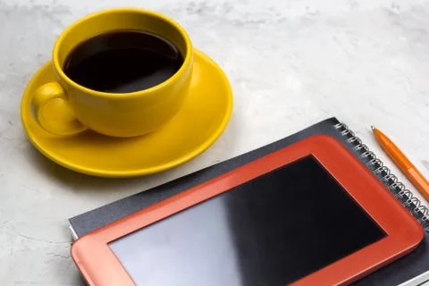 Coffee cup,tablet,notebook and pen on a table Stock-Fotos