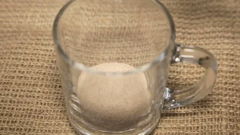 Coffee drink filled with boiling water in a glass cup on sacking Stock Footage 71925229