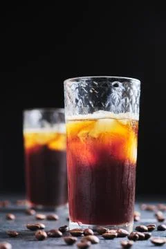 Coffee drink with ice in a glass glass. Iced coffee on the table close-up. Stock Photos