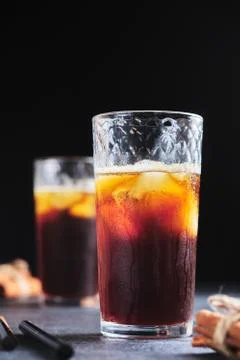 Coffee drink with ice in a glass glass. Iced coffee on the table close-up. Stock Photos