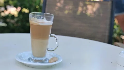Coffee drink latte or flat white, in a transparent glass with cookie or biscuit  Stock Footage 162389795