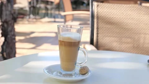 Coffee drink latte or flat white, in a transparent glass with cookie or biscuit  Stock Footage 162390062
