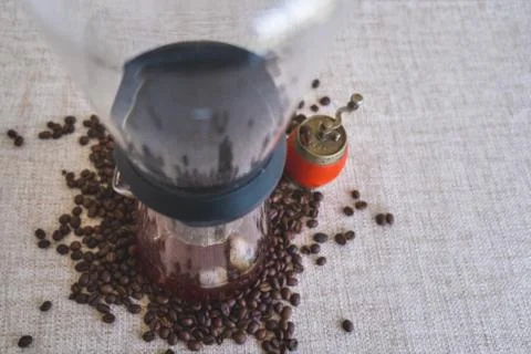 Coffee drip brewing machine, with coffee beans and an old grinder around. Stock Photos