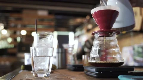 Coffee drip process by pouring hot water from kettle though ground berries bean Video stock 171782861