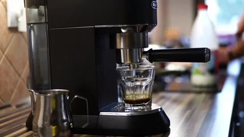 Coffee drips from a coffee machine into a glass on a stand Stock Footage 279308384