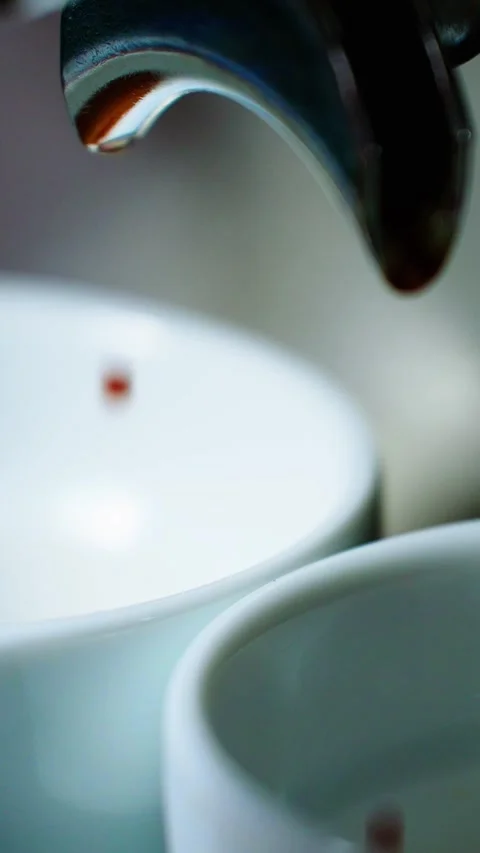 Coffee drips from espresso machine into white cups at a cozy cafe Stock Footage 342797625