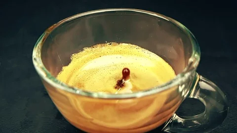 Coffee drop falling in slow motion inside of trasparent cup of espresso Video stock 92748023