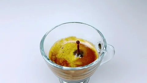 Coffee drop falling in slow motion inside of trasparent cup of espresso italian Видео 94240392