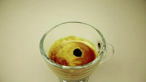 Coffee drop falling in slow motion inside of trasparent cup of espresso Video stock 95902448