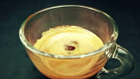 Coffee drop falling in slow motion inside of trasparent cup of espresso italian Stock Footage 95903747