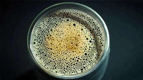 Coffee drop into the filled glass in slow motion. Stock Footage 162119082