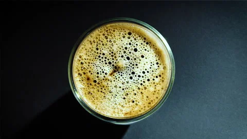 Coffee drop into the filled glass in slow motion. Stock Footage 162128755