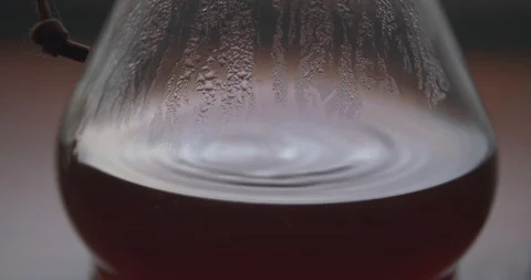 Coffee Droplets Causing Ripples in a Steamy Chemex Stock Footage 100088826