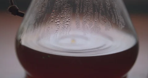 Coffee Droplets Causing Ripples in a Steamy Chemex Stock Footage 100091616