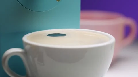 Coffee drops poured into cup from espresso coffee machine on colorful purple Video stock 146169096