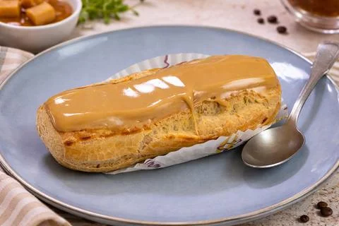 Coffee eclair topped with shiny icing Stock Photos