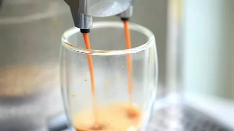 Coffee espresso streaming from coffee machine and pouring into glass. Stock Footage 143017445