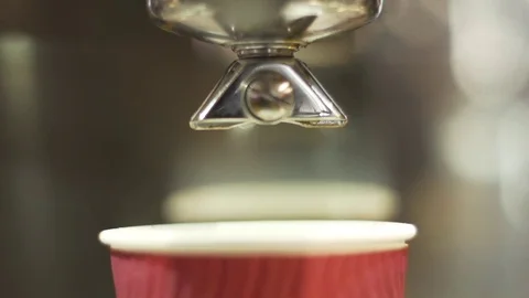 Coffee falling in the cup from coffee machine in slow motion Stockbeeldmateriaal 73021576
