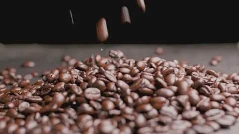 Coffee falling onto a heap with a plain black background in slow motion Stock Footage 148448764