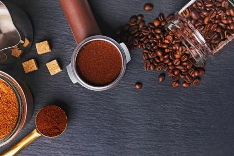 Coffee filter holder with and roasted beans scattered around on black background Stock Photos