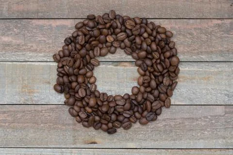 Coffee flat lay: empty circle surrounded by coffee beans on a wooden background Fotos de archivo