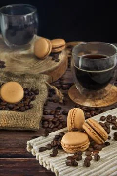 Coffee flavor macarons with coffee beans and cups of coffee Stock Photos
