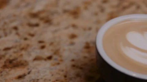 Coffee with flower drawing served on a table in a restaurant. Stock Footage 148476479