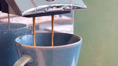 Coffee flowing from a coffee machine into a cup Video stock 280452637