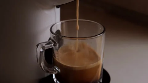 Coffee flows being prepared pours from a white coffee machine or coffee makers Stock Footage 246874385