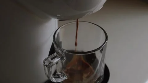 Coffee flows being prepared pours from a white coffee machine or coffee makers Stock Footage 247819283