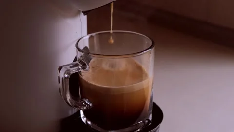 Coffee flows being prepared pours from a white coffee machine or coffee makers Stock Footage 269192558