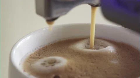 Coffee flows into the cup. A jet of coffee flows into the white cup from the Stock Footage 154607275