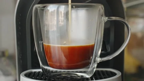 Coffee flows into glass cup prepared in coffee machine close-up slow motion Stock Footage 238552907