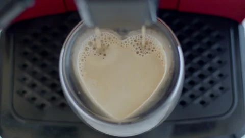 Coffee with foam is poured from a coffee machine into a heart-shaped glass Video stock 198588423