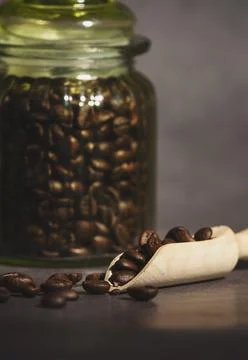 Coffee in a glass jar on a rustic table. Selective focus. coffee beans in a w Stock Photos