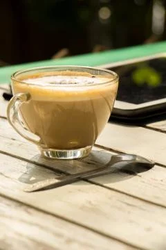 Coffee, glasses, the tablet placed on a table. Stock Photos