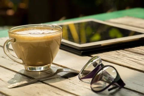 Coffee, glasses, the tablet placed on a table. Stock-Fotos