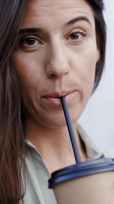 Coffee to go. coffee. latte. coffee drink. a young woman drinks through a straw Stock Footage 317847080
