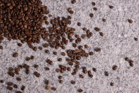 Coffee grains on a beige background from solid granite. Stock Photos